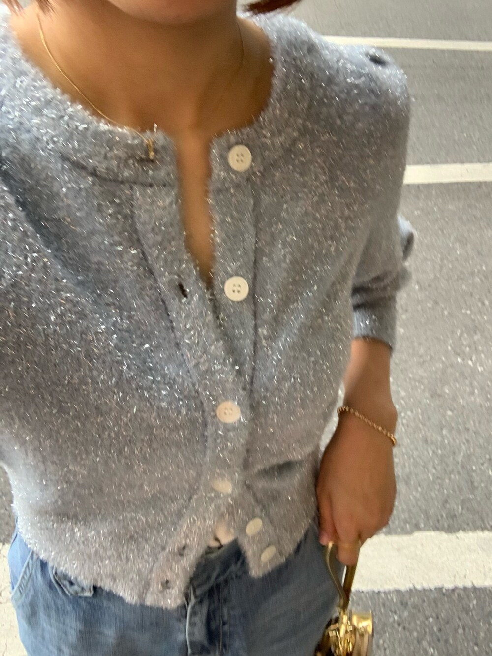 ブルー系のカーディガン/ボレロ、ゴールド系のショルダーバッグ、ブルー系のデニムパンツを着用したレディースの秋コーディネートの5枚目の写真