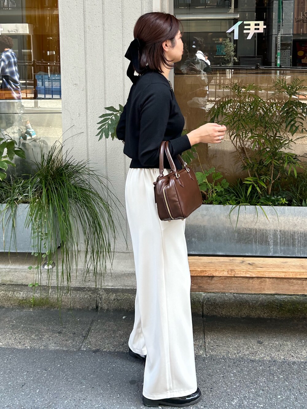 ホワイト系のその他パンツ、ブラウン系のハンドバッグ、ブラック系のニット/セーターを着用したレディースの秋コーディネートの5枚目の写真