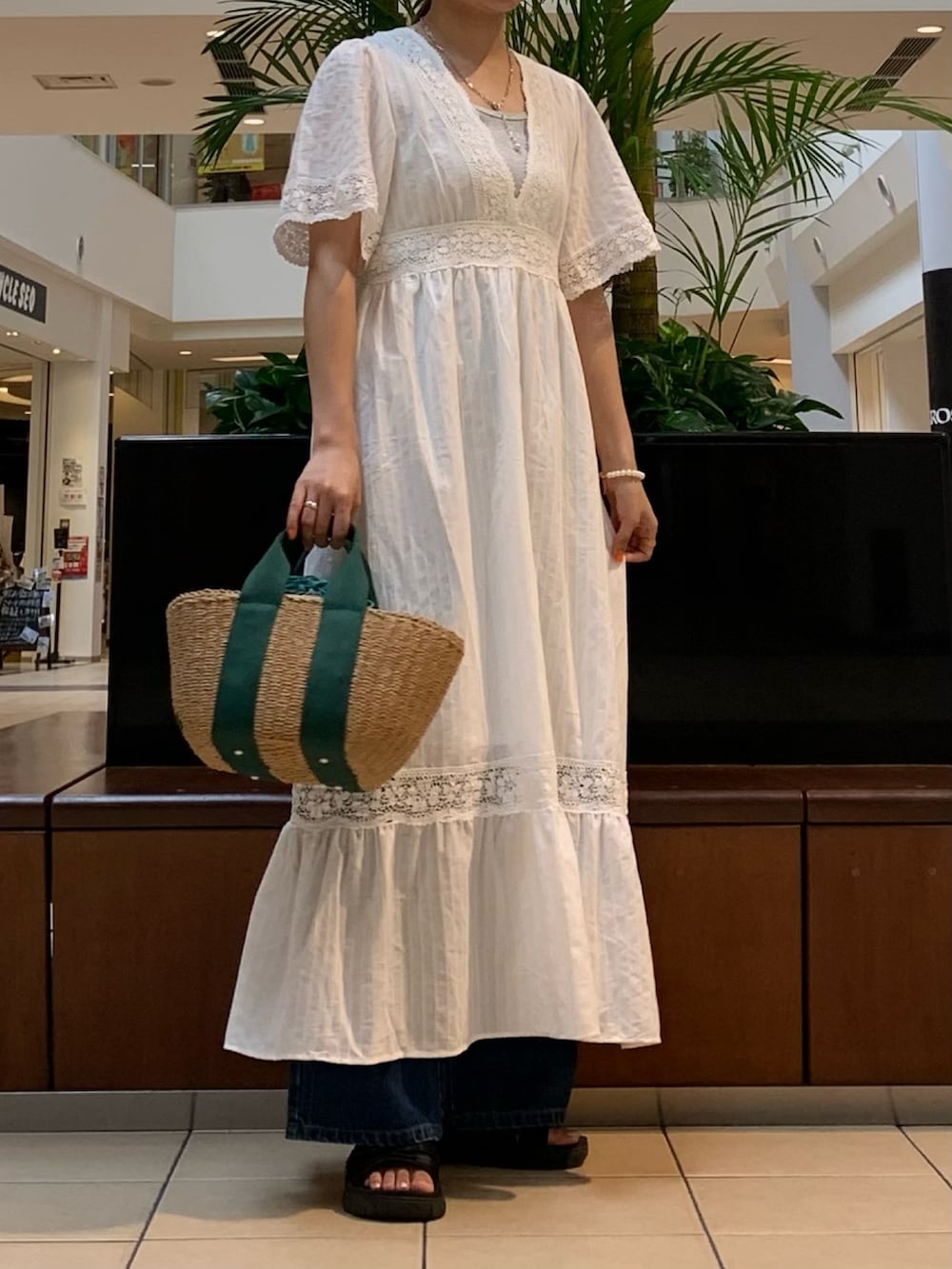 ホワイト系のワンピース、シルバー系のTシャツ/カットソー、ブルー系のデニムパンツを着用したレディースの夏コーディネートの3枚目の写真