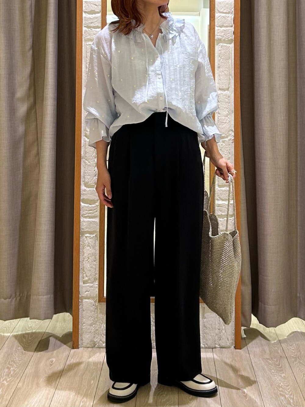 ブラック系のスラックス、シルバー系のトートバッグ、ブルー系のシャツ/ブラウスを着用したレディースの春コーディネートの4枚目の写真