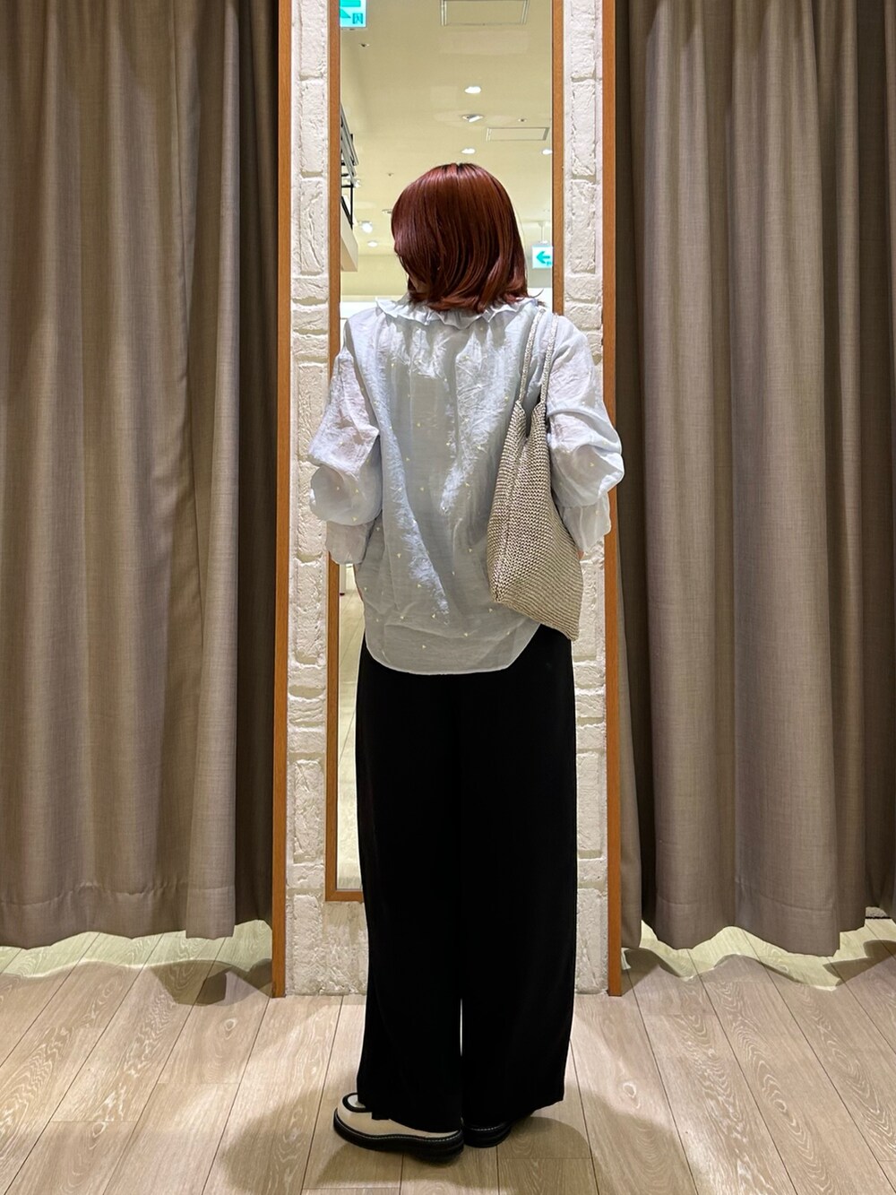 ブラック系のスラックス、シルバー系のトートバッグ、ブルー系のシャツ/ブラウスを着用したレディースの春コーディネートの3枚目の写真