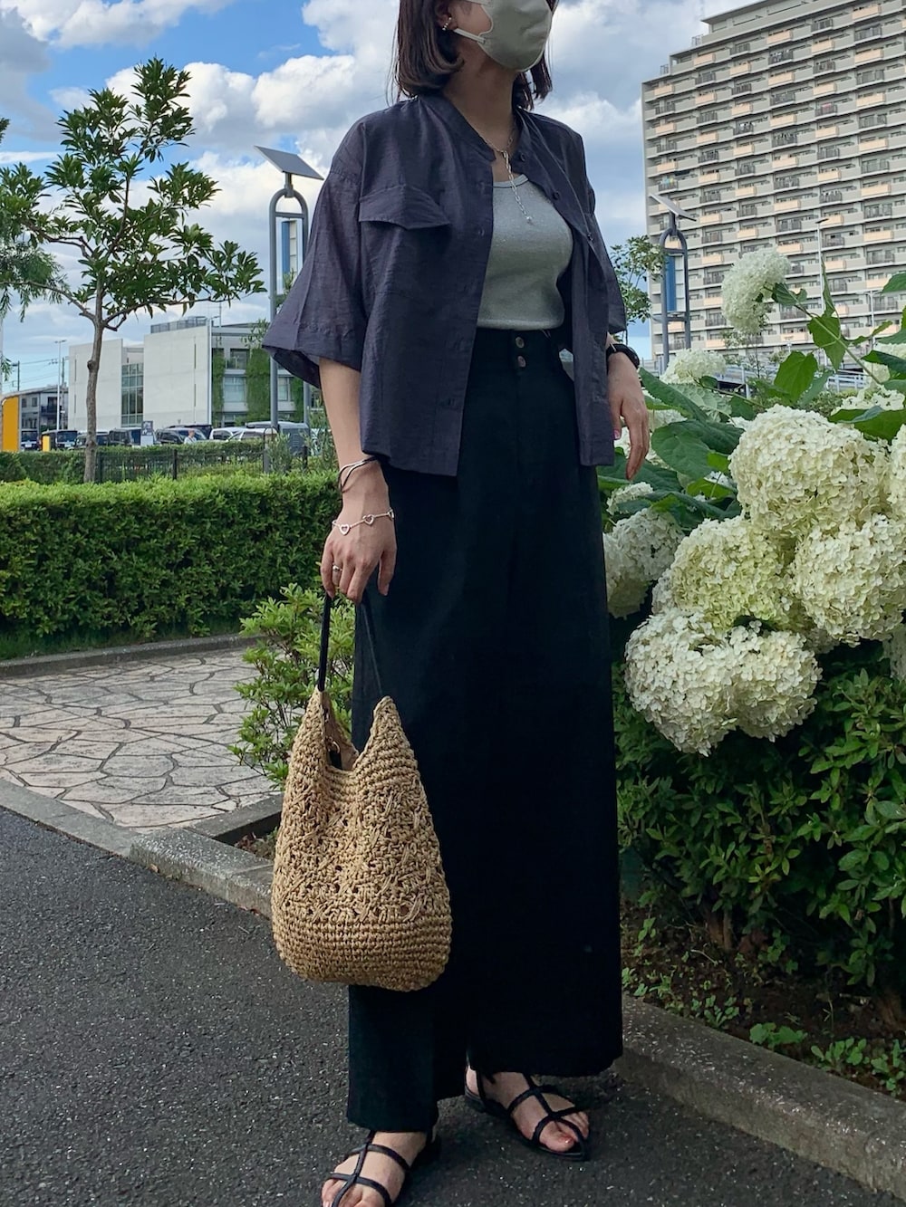 ブラック系のかごバッグ、ブラック系のスラックス、グレー系のシャツ/ブラウスを着用したレディースの夏コーディネートの4枚目の写真