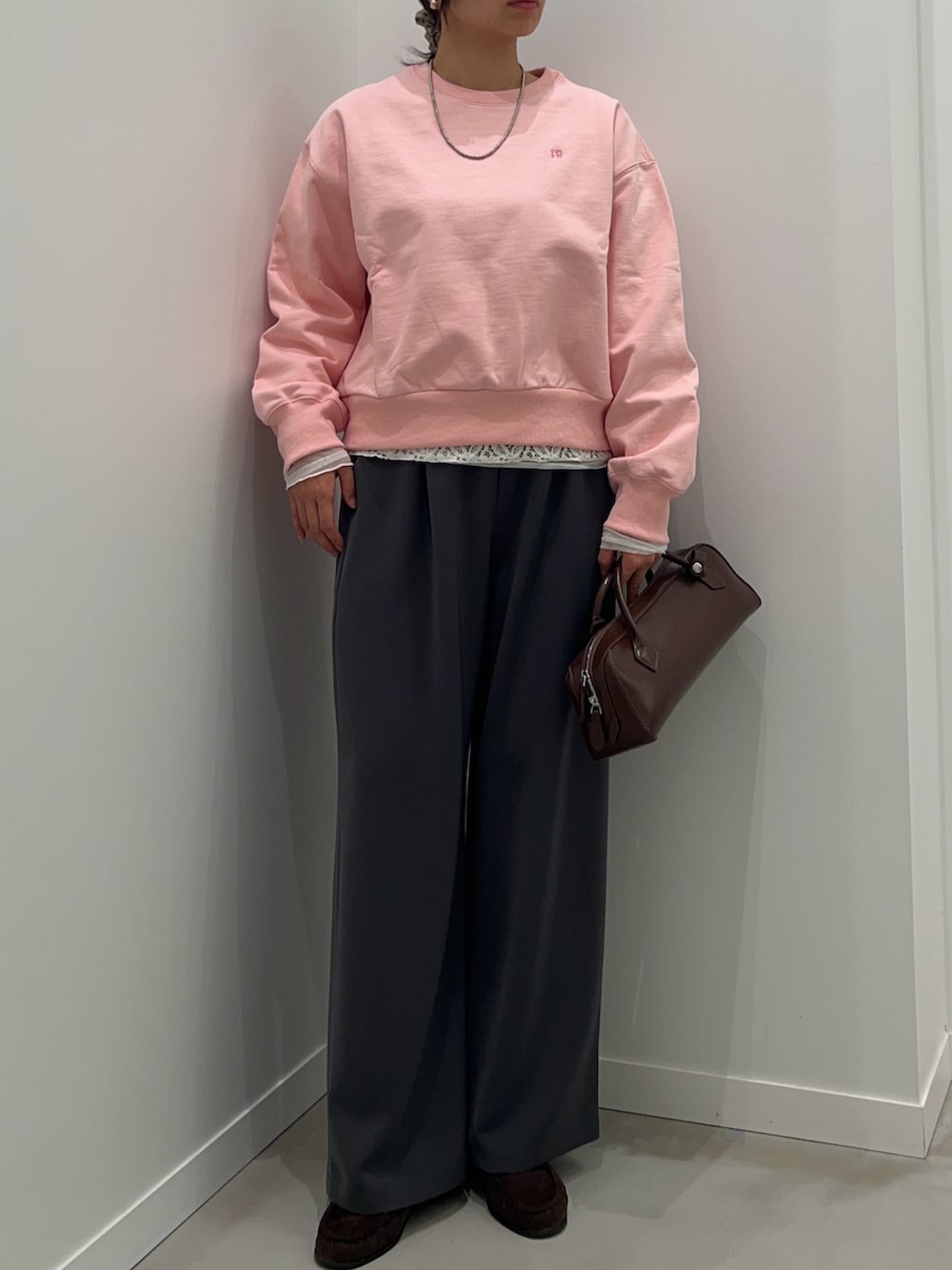 グレー系のその他パンツ、ブラウン系のショルダーバッグ、ピンク系のスウェットを着用したレディースの冬コーディネートの3枚目の写真