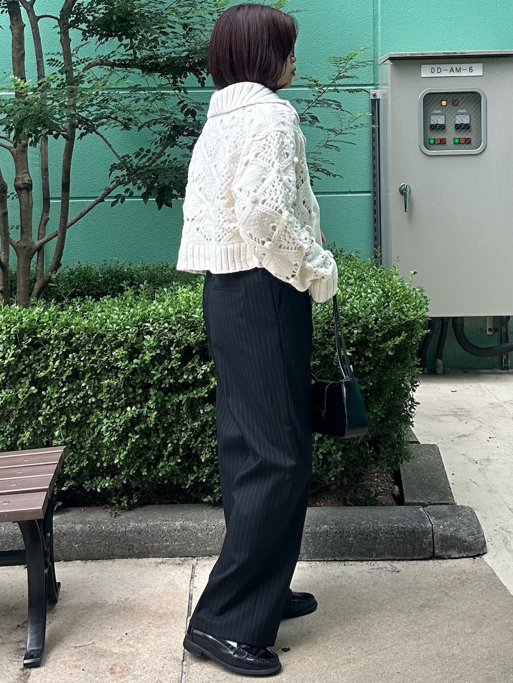 ブルー系のスラックス、ホワイト系のニット/セーター、ホワイト系のTシャツ/カットソーを着用したレディースの秋コーディネートの2枚目の写真