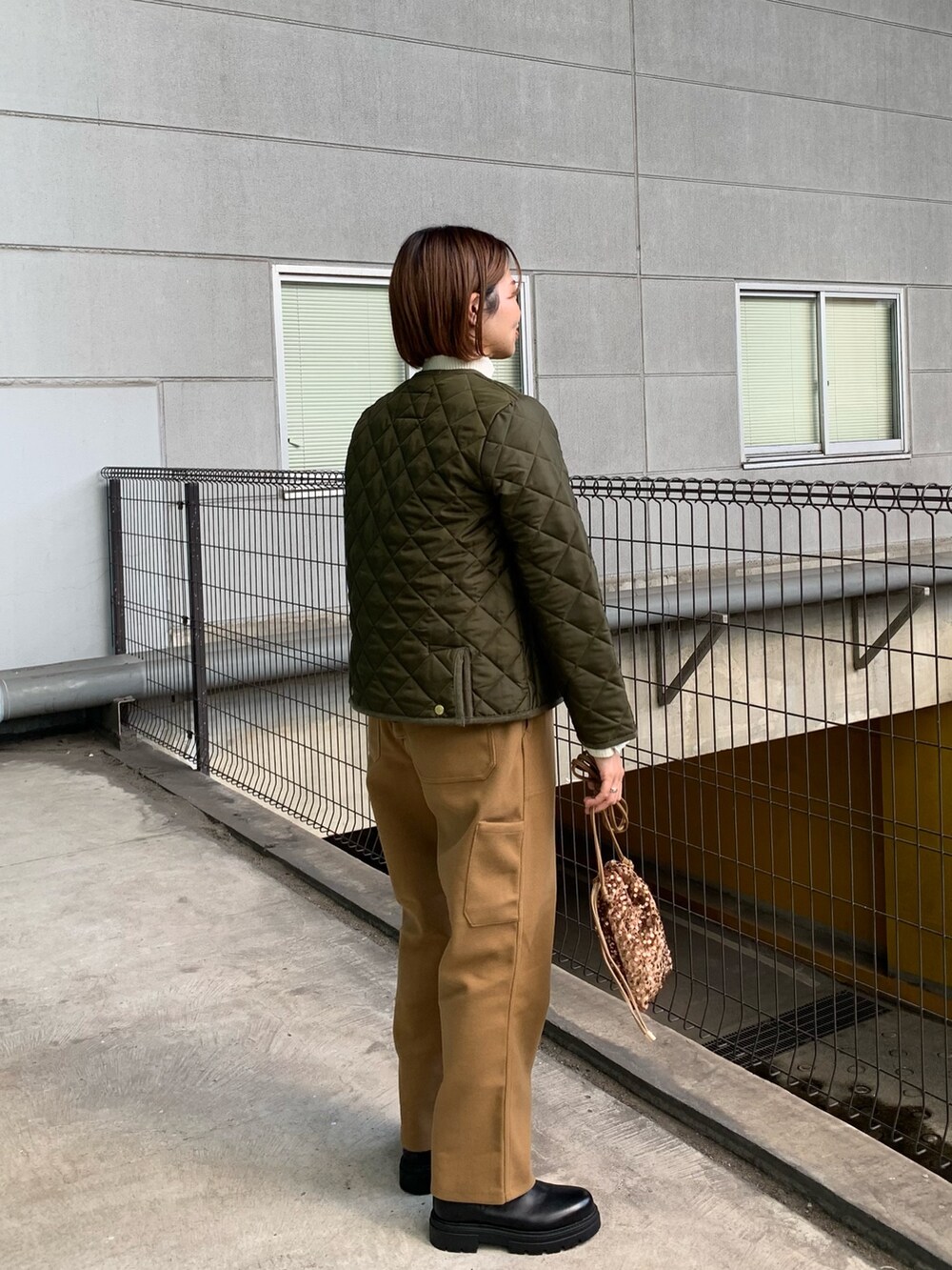 グリーン系のブルゾン、ブラウン系のその他パンツ、ブラック系のブーツを着用したレディースの秋コーディネートの3枚目の写真