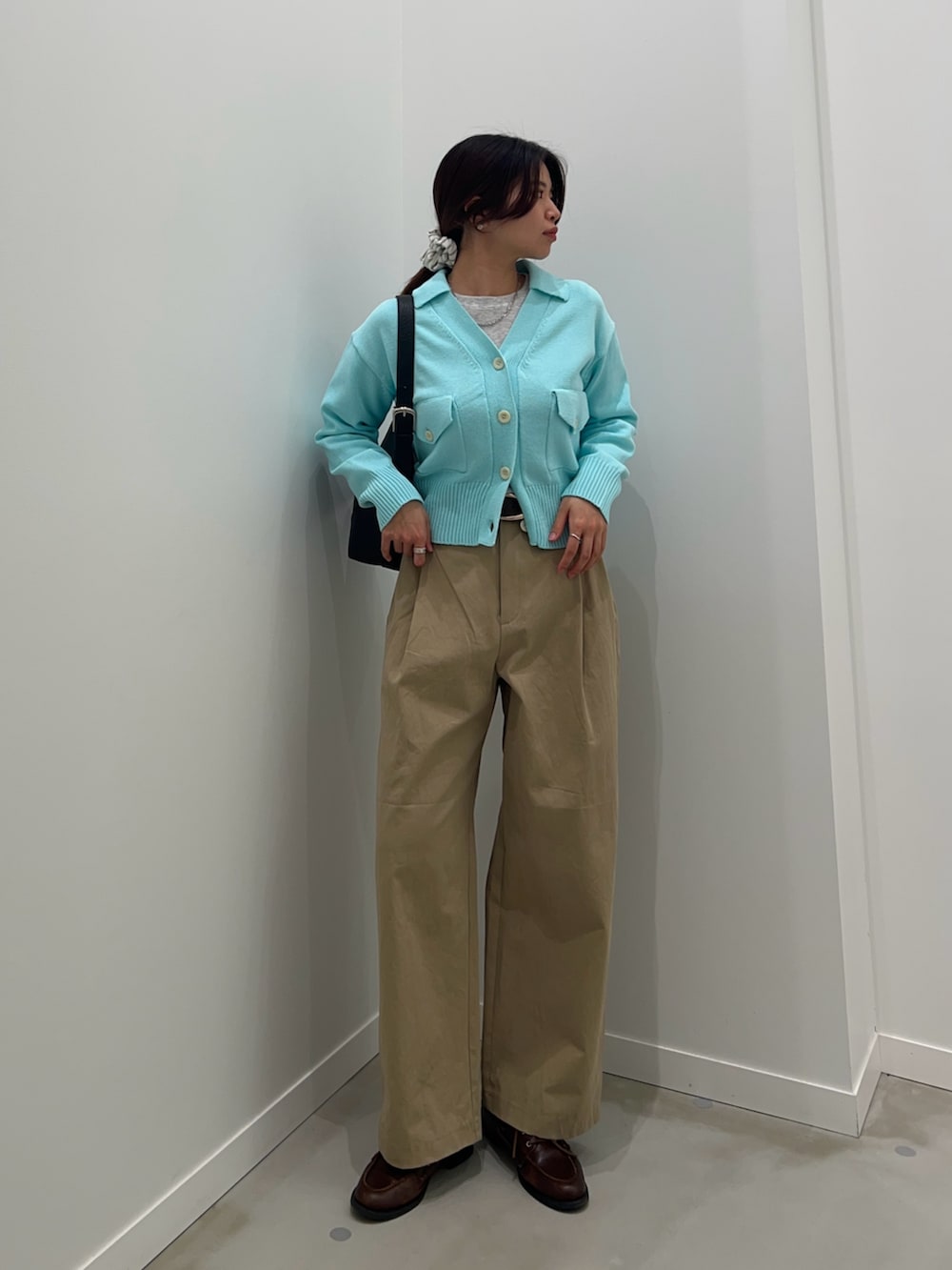 ベージュ系のチノパンツ、ブルー系のカーディガン/ボレロ、グレー系のTシャツ/カットソーを着用したレディースの冬コーディネートの3枚目の写真