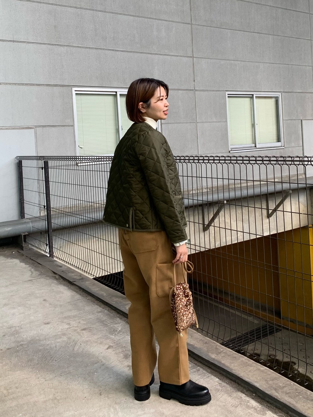 グリーン系のブルゾン、ブラウン系のその他パンツ、ブラック系のブーツを着用したレディースの秋コーディネートの2枚目の写真