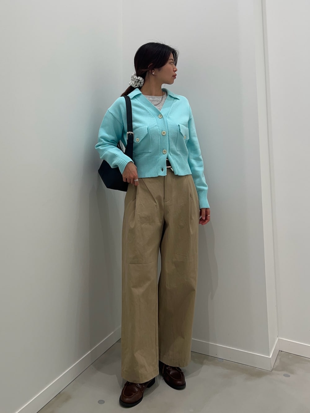 ベージュ系のチノパンツ、ブルー系のカーディガン/ボレロ、グレー系のTシャツ/カットソーを着用したレディースの冬コーディネートの2枚目の写真