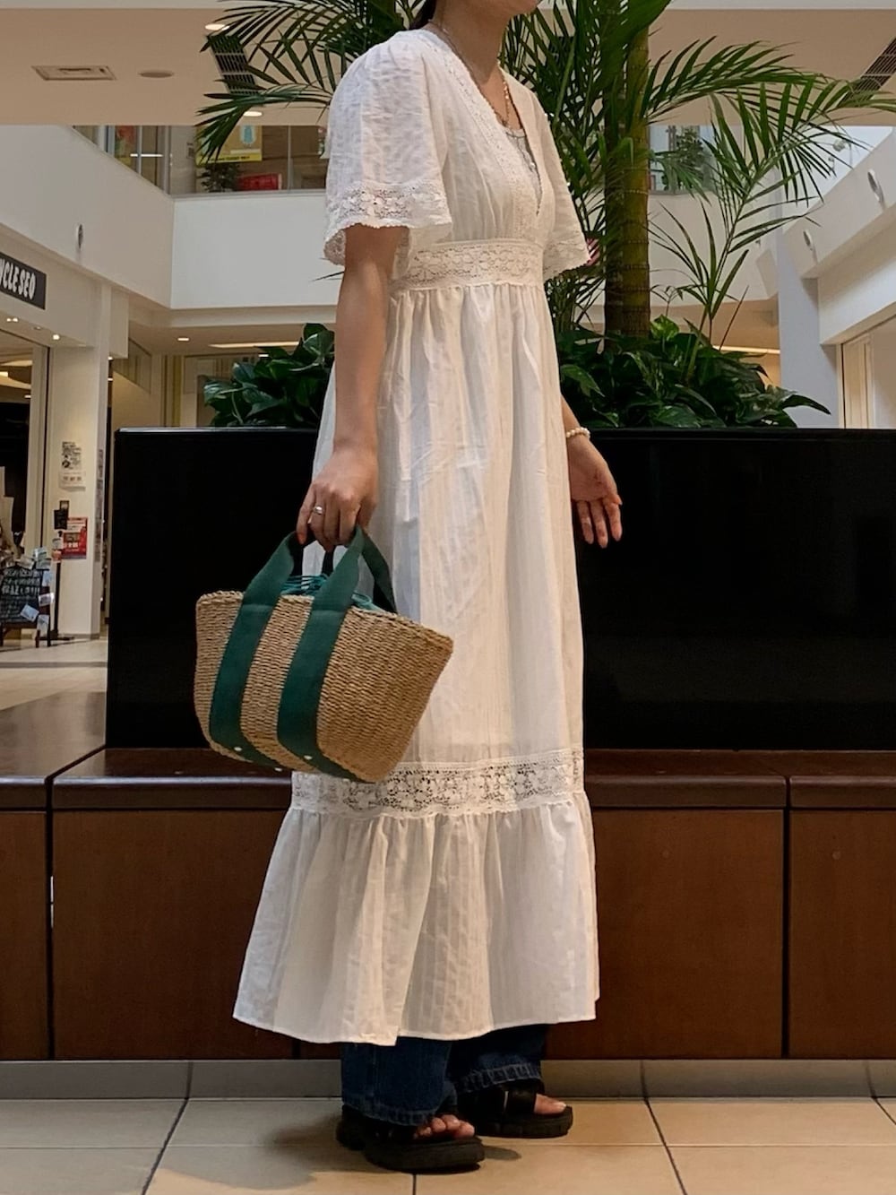 ホワイト系のワンピース、シルバー系のTシャツ/カットソー、ブルー系のデニムパンツを着用したレディースの夏コーディネートの2枚目の写真