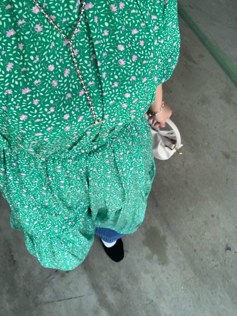 グリーン系のワンピース、ブルー系のデニムパンツ、ホワイト系のトートバッグを着用したレディースの春コーディネートの4枚目の写真