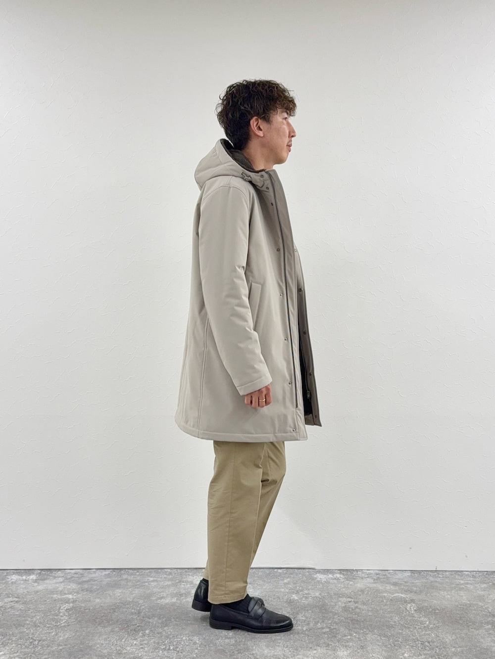 グレー系のニット/セーター、ベージュ系のその他アウター、ブラック系のローファーを着用したメンズの秋コーディネートの3枚目の写真