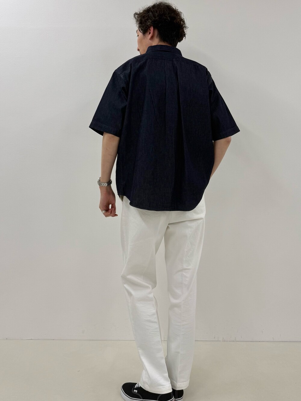 ブルー系のシャツ/ブラウス、ブラック系のトートバッグ、ホワイト系のデニムパンツを着用したメンズの春コーディネートの3枚目の写真