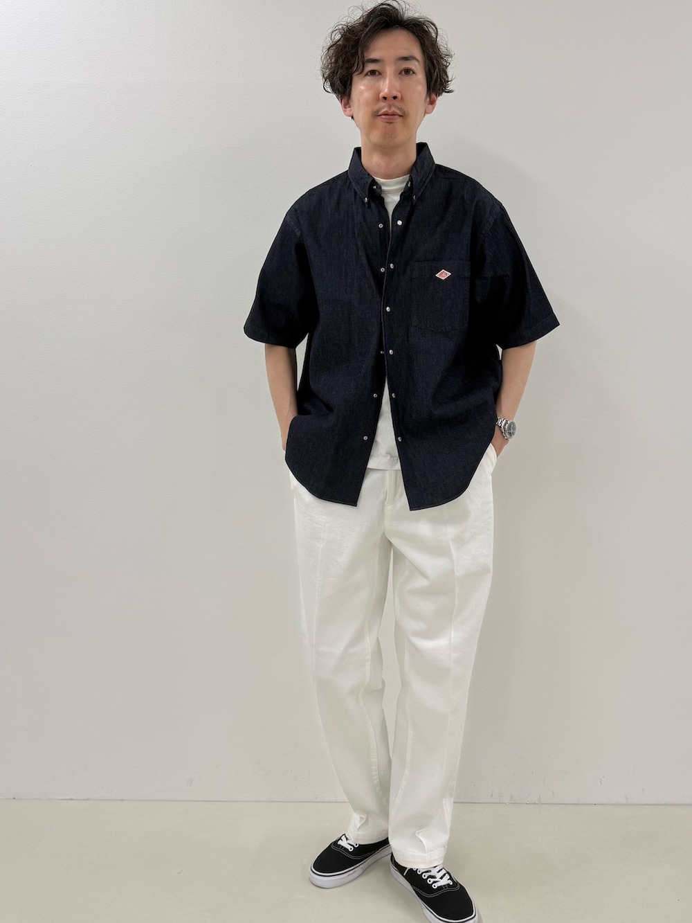 ブルー系のシャツ/ブラウス、ブラック系のトートバッグ、ホワイト系のデニムパンツを着用したメンズの春コーディネートの2枚目の写真