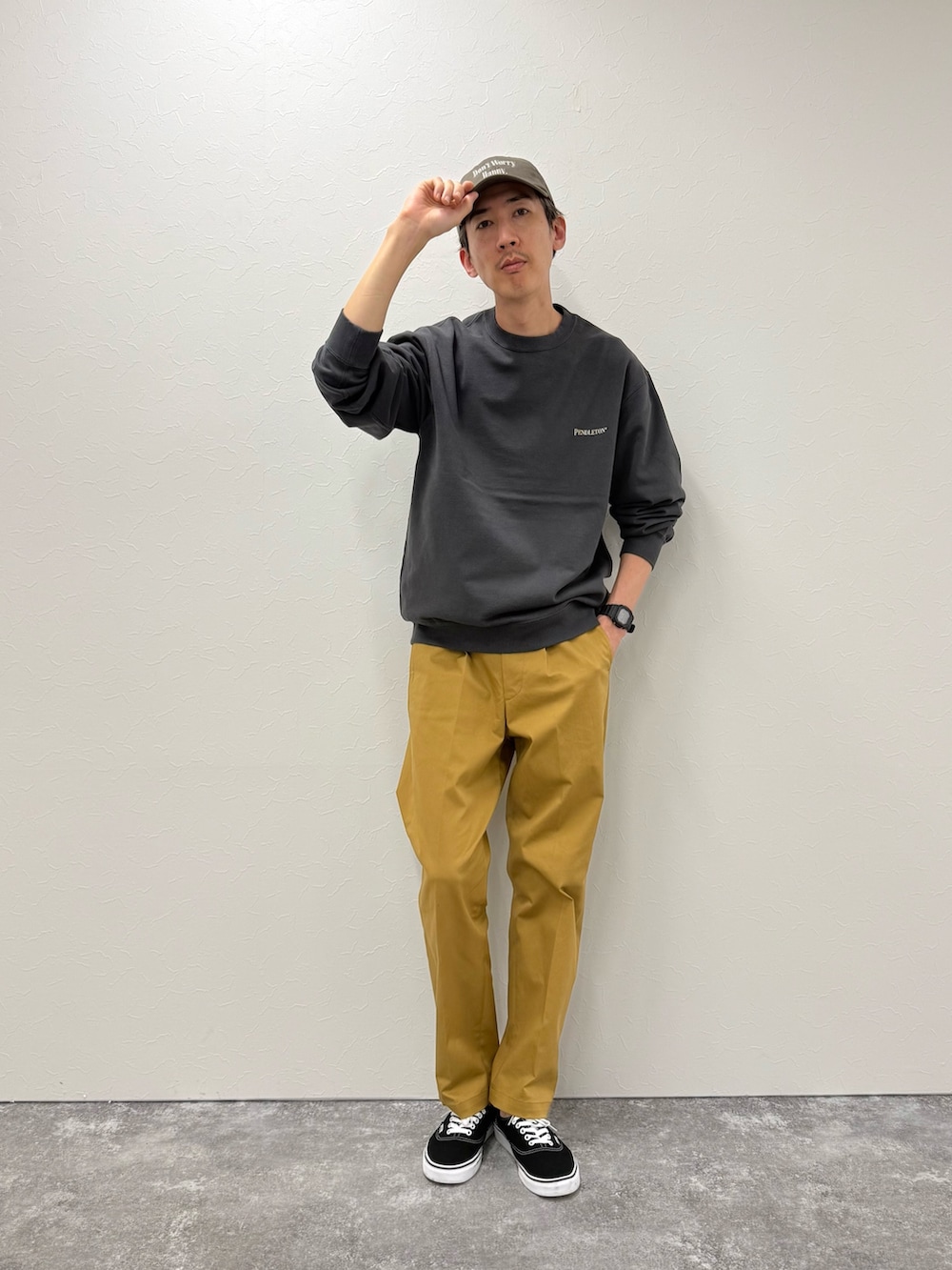 グレー系のスウェット、ベージュ系のチノパンツ、ブルー系のキャップを着用したメンズの秋コーディネートの3枚目の写真