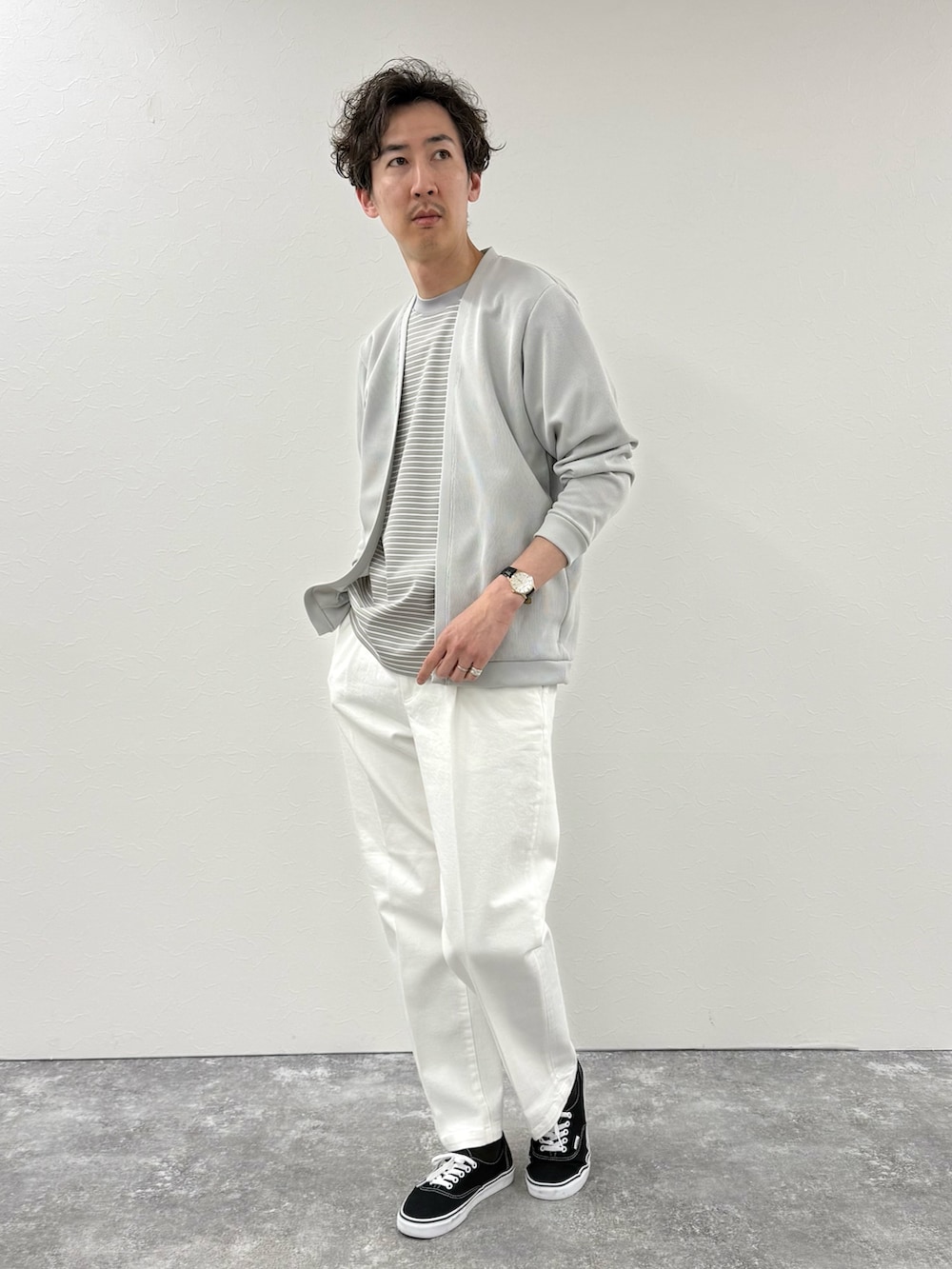 ホワイト系のデニムパンツ、グレー系のTシャツ/カットソー、ベージュ系のカーディガン/ボレロを着用したメンズの春コーディネートの2枚目の写真