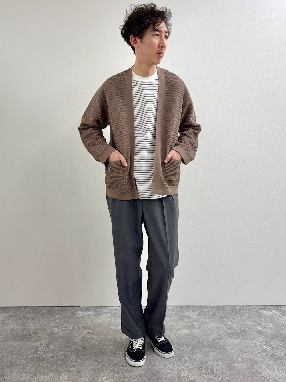 ブラック系のショルダーバッグ、ホワイト系のTシャツ/カットソー、グレー系のスラックスを着用したメンズの春コーディネートの3枚目の写真