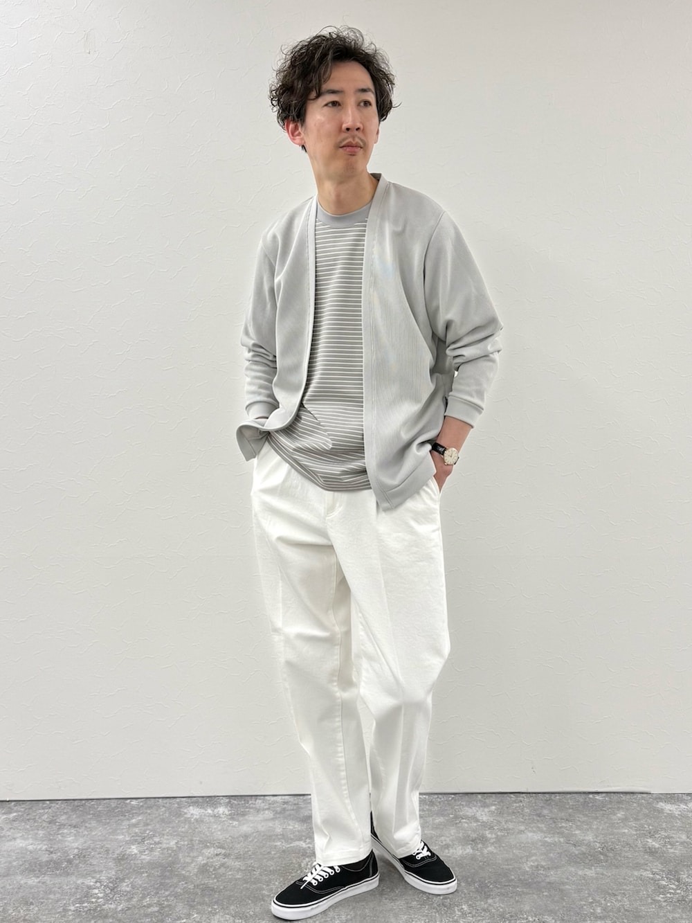 ホワイト系のデニムパンツ、グレー系のTシャツ/カットソー、ベージュ系のカーディガン/ボレロを着用したメンズの春コーディネートの3枚目の写真