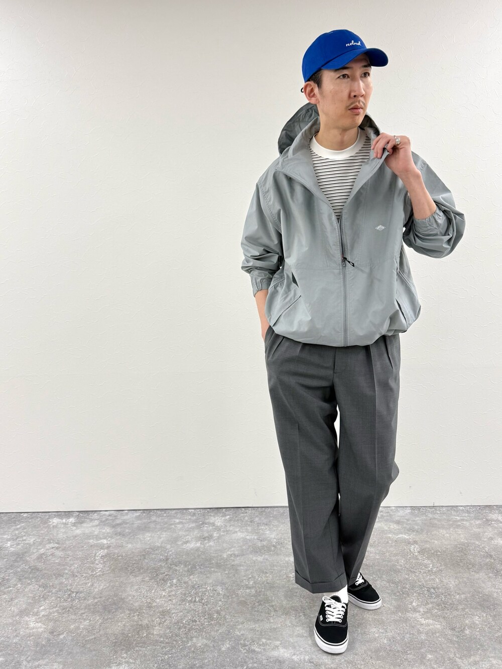 ホワイト系のTシャツ/カットソー、ブルー系のブルゾン、グレー系のスラックスを着用したメンズの冬コーディネートの2枚目の写真