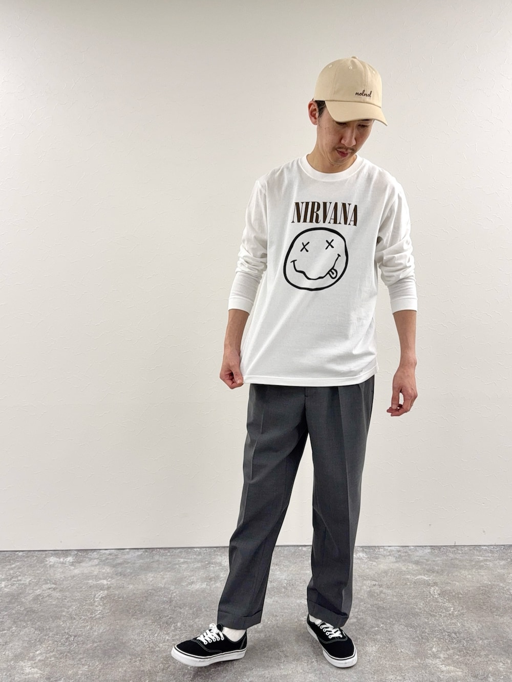 ホワイト系のTシャツ/カットソー、グレー系のスラックス、ホワイト系のキャップを着用したメンズの冬コーディネートの2枚目の写真