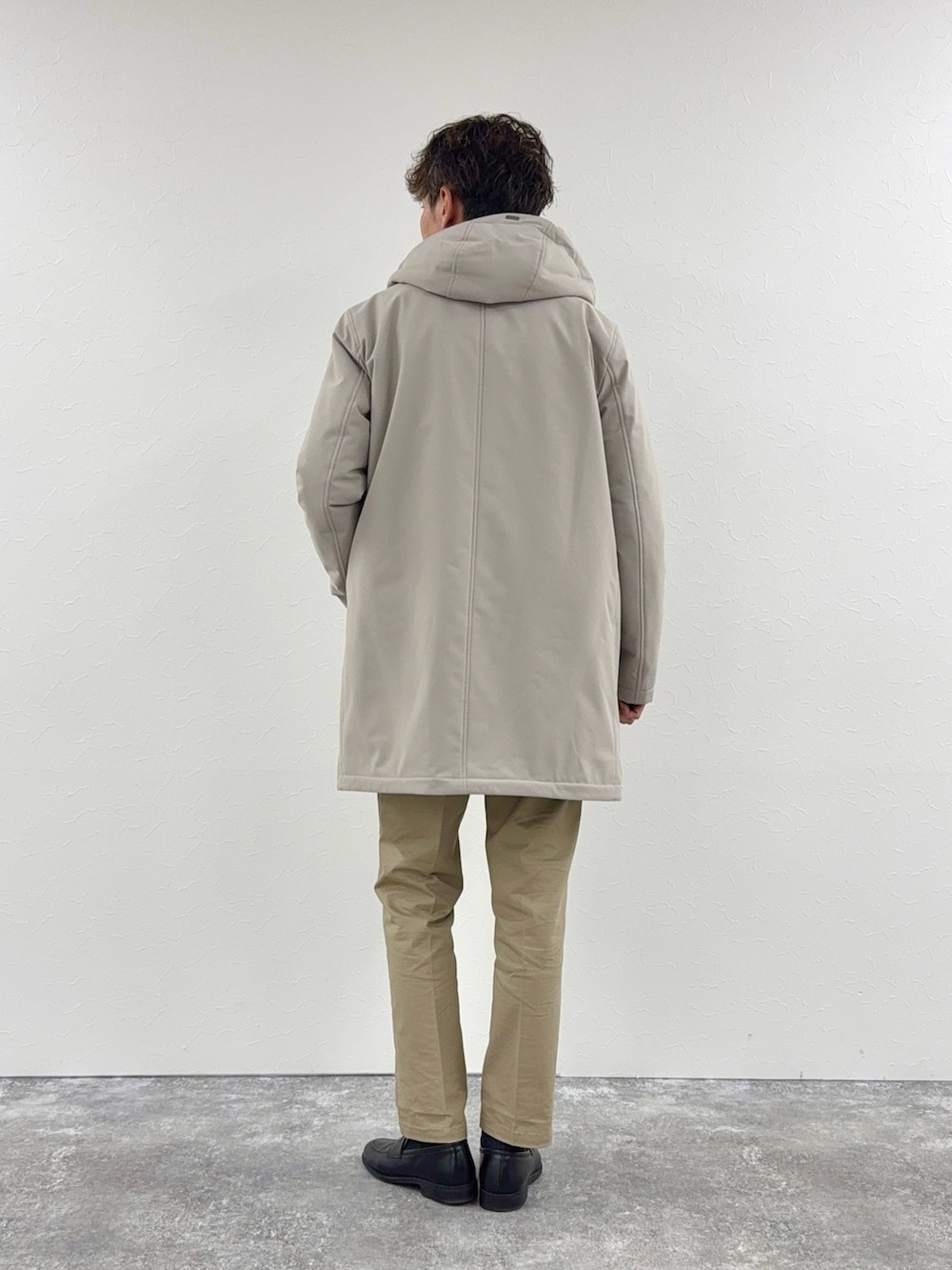 グレー系のニット/セーター、ベージュ系のその他アウター、ブラック系のローファーを着用したメンズの秋コーディネートの2枚目の写真