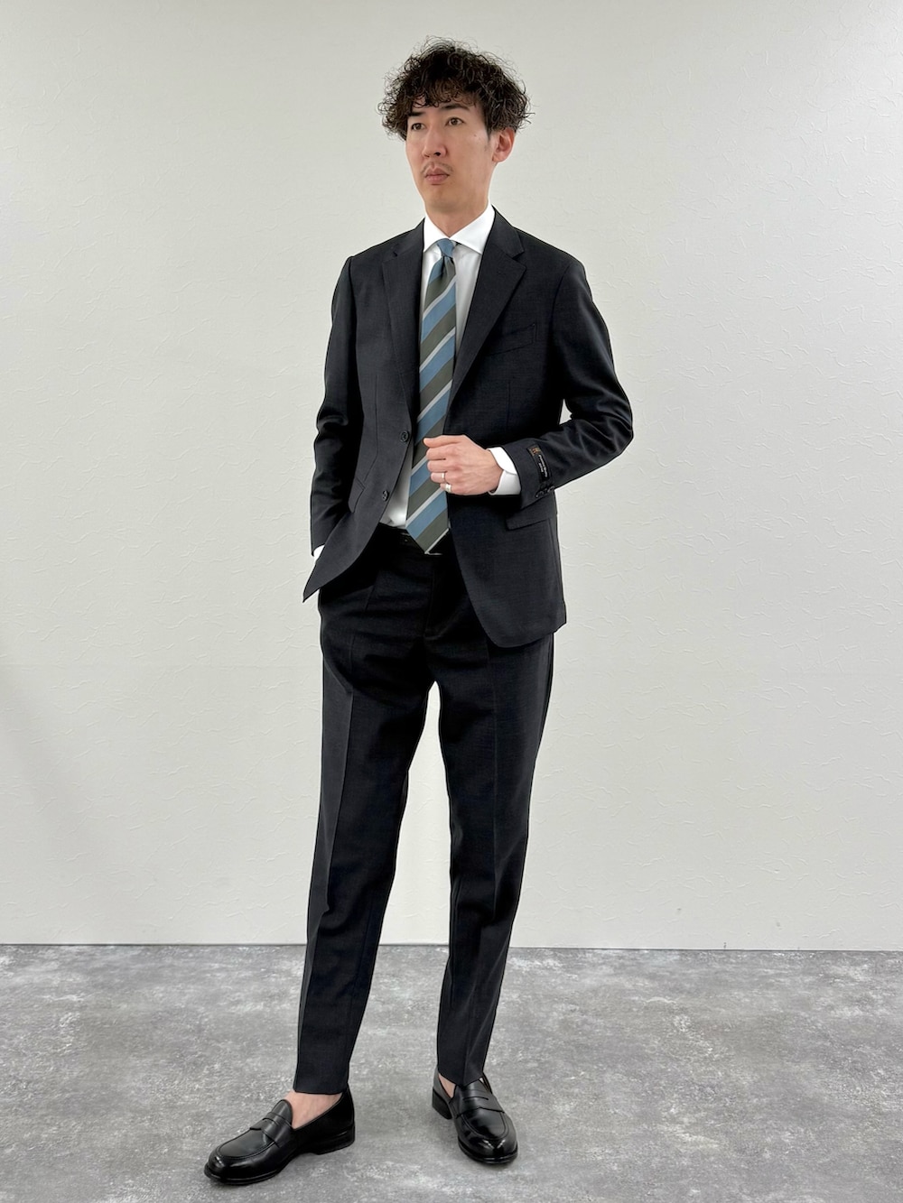 グレー系のセットアップ、ブルー系のネクタイ、ホワイト系のシャツ/ブラウスを着用したメンズの冬コーディネートの3枚目の写真