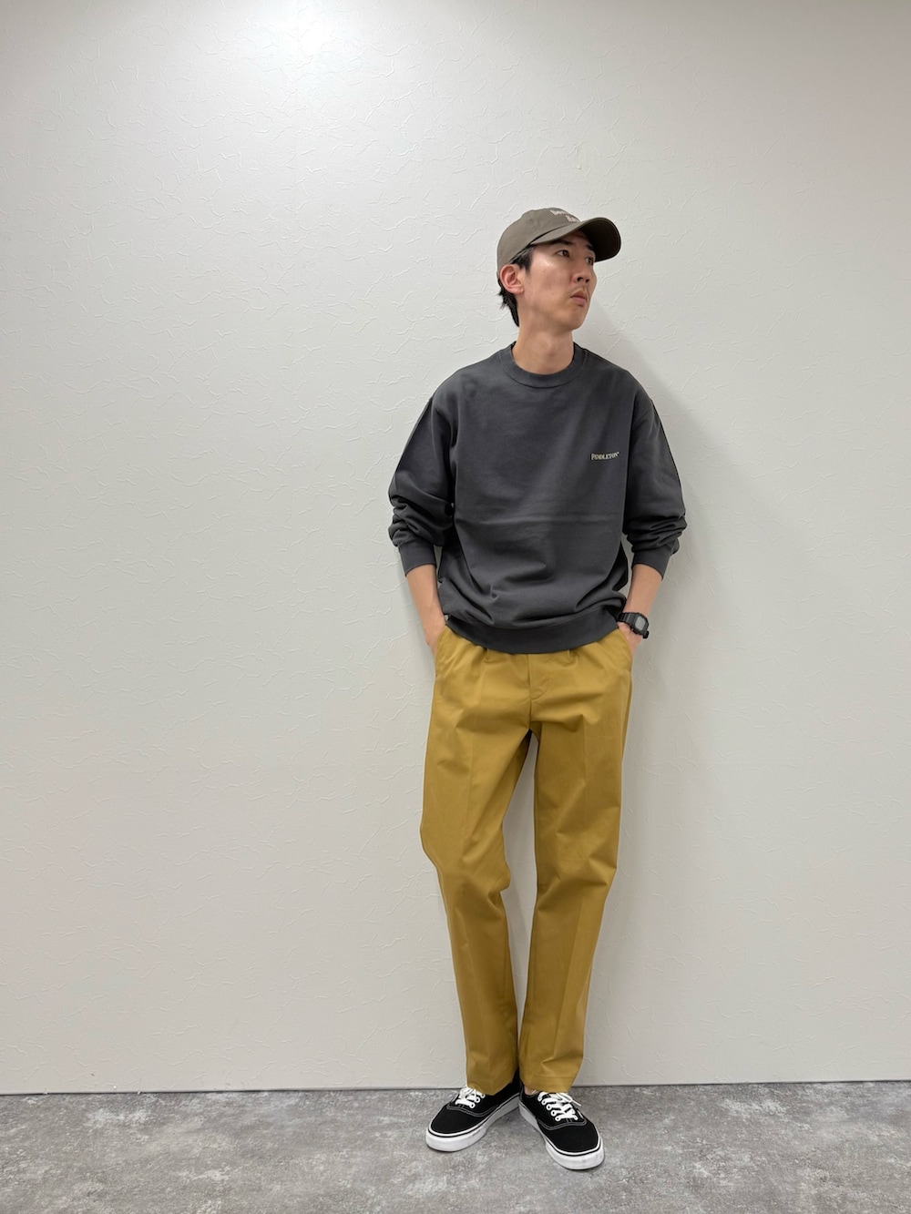 グレー系のスウェット、ベージュ系のチノパンツ、ブルー系のキャップを着用したメンズの秋コーディネートの2枚目の写真