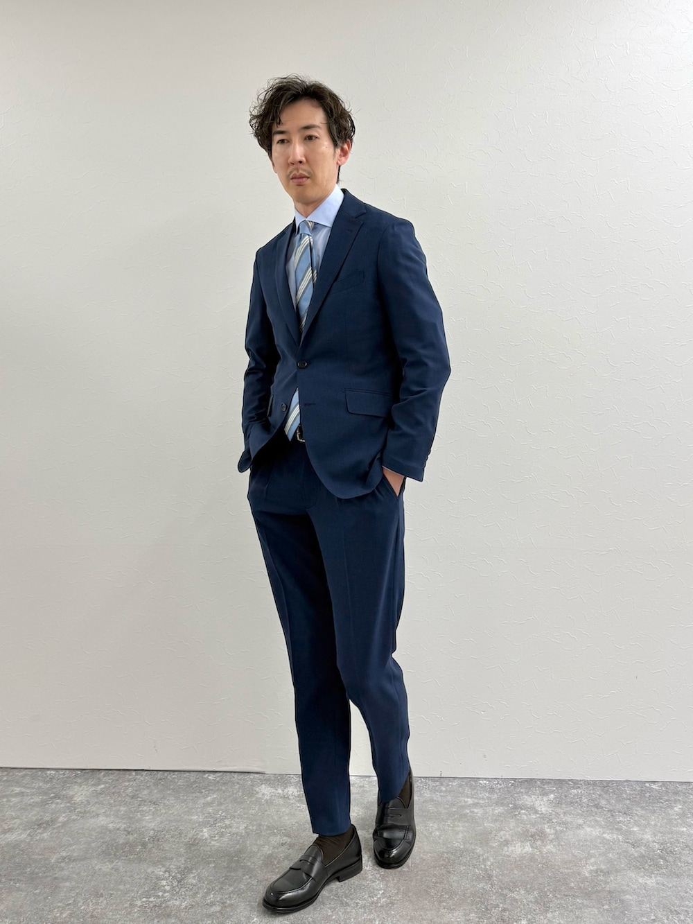 ブルー系のスラックス、ブラック系のローファー、ブルー系のシャツ/ブラウスを着用したメンズの冬コーディネートの2枚目の写真