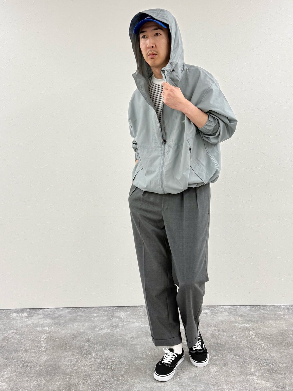 ホワイト系のTシャツ/カットソー、ブルー系のブルゾン、グレー系のスラックスを着用したメンズの冬コーディネートの3枚目の写真