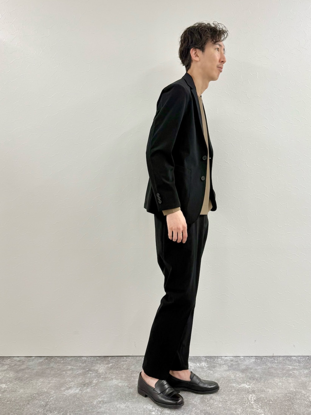 ブラック系のテーラードジャケット、ブラック系のその他パンツ、イエロー系のTシャツ/カットソーを着用したメンズの秋コーディネートの2枚目の写真