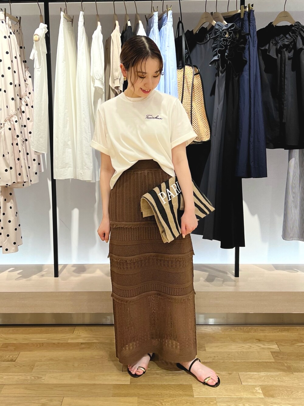 ホワイト系のTシャツ/カットソー、ブラウン系のスカートを着用したレディースの夏コーディネートの2枚目の写真