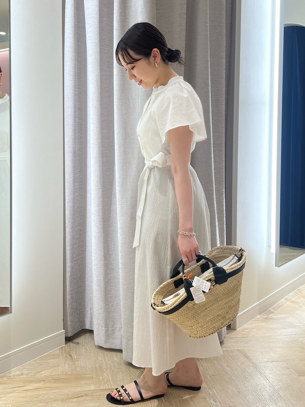 ホワイト系のワンピース、ブラック系のかごバッグを着用したレディースの夏コーディネートの2枚目の写真