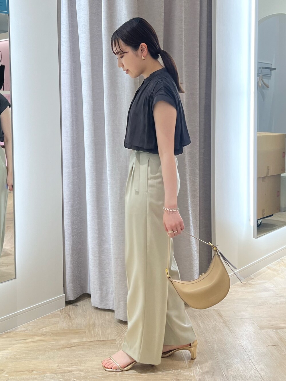 ベージュ系のその他パンツ、グレー系のシャツ/ブラウス、ベージュ系のショルダーバッグを着用したレディースの夏コーディネートの2枚目の写真