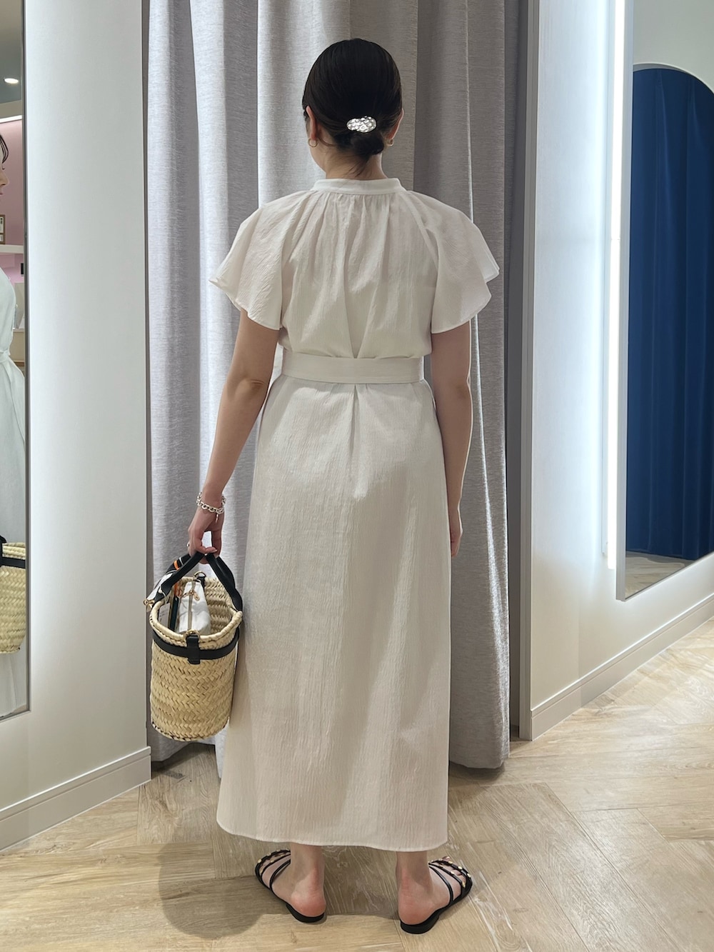 ホワイト系のワンピース、ブラック系のかごバッグを着用したレディースの夏コーディネートの3枚目の写真