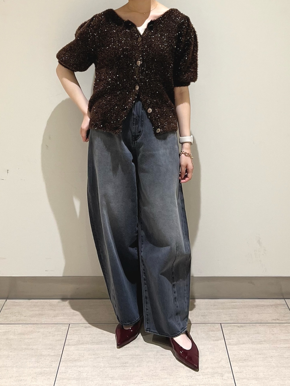 ブラック系のデニムパンツ、ブラウン系のニット/セーターを着用したレディースの秋コーディネートの3枚目の写真