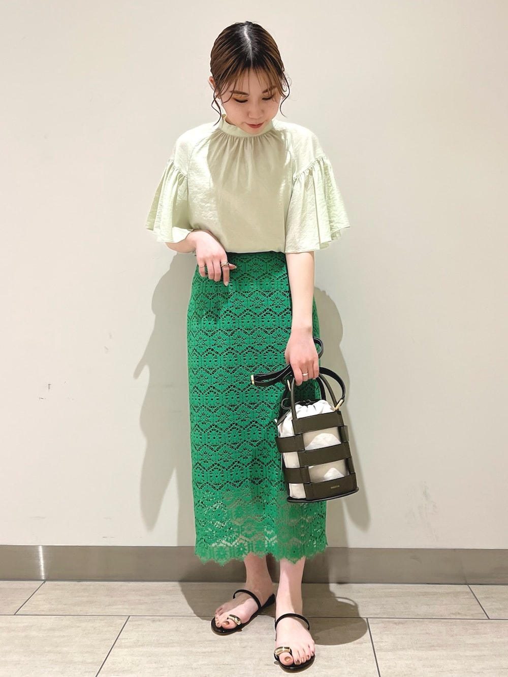 グリーン系のスカート、グリーン系のシャツ/ブラウスを着用したレディースの春コーディネートの2枚目の写真