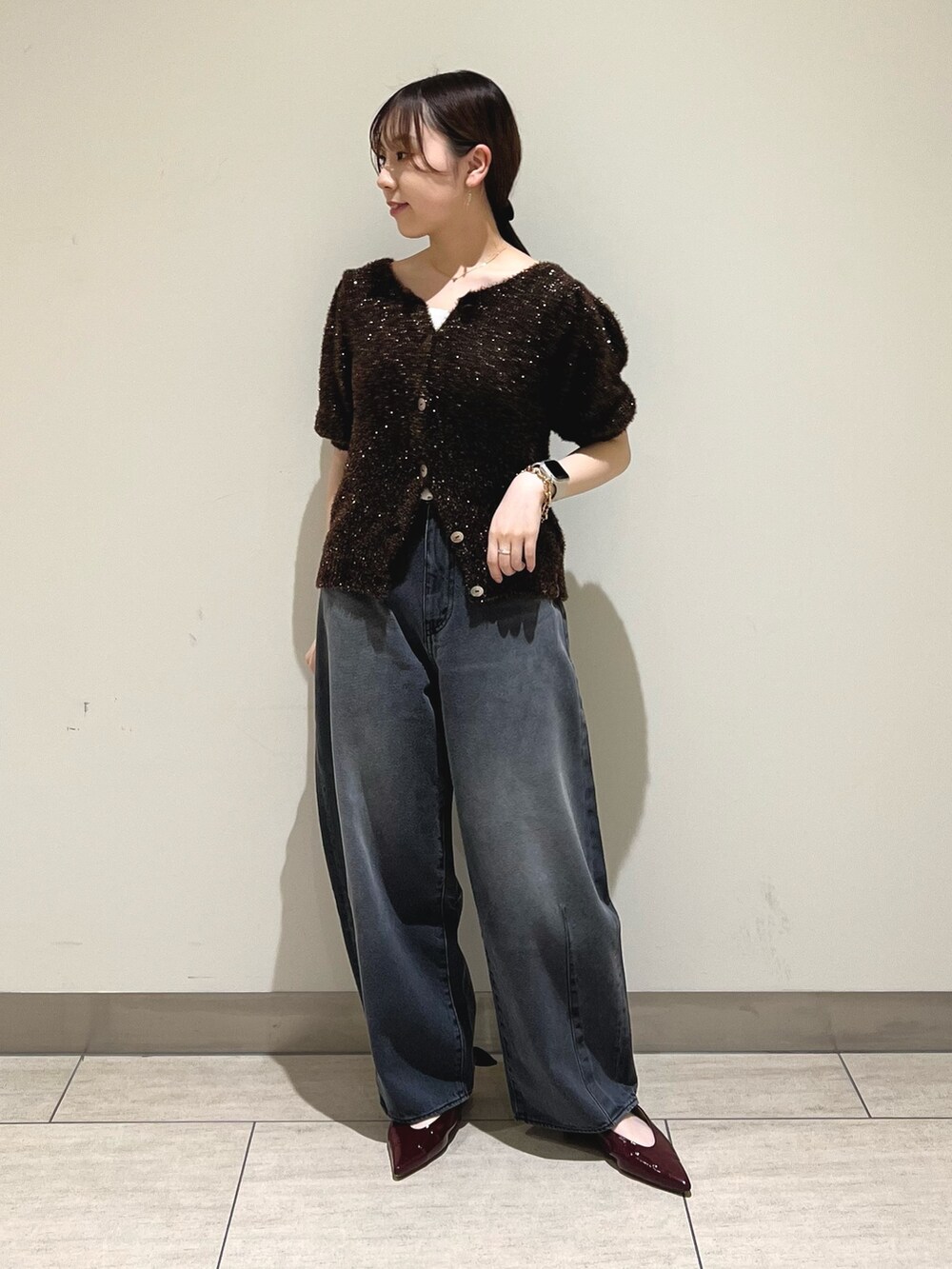 ブラック系のデニムパンツ、ブラウン系のニット/セーターを着用したレディースの秋コーディネートの5枚目の写真