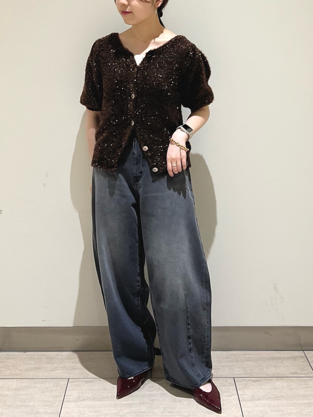 ブラック系のデニムパンツ、ブラウン系のニット/セーターを着用したレディースの秋コーディネートの4枚目の写真