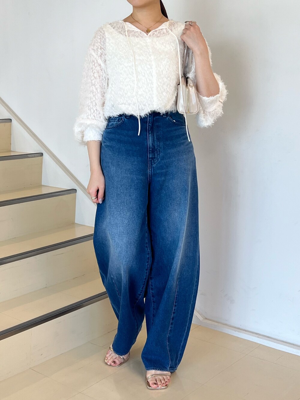 ブルー系のデニムパンツ、ホワイト系のシャツ/ブラウス、ホワイト系のボストンバッグを着用したレディースの夏コーディネートの4枚目の写真