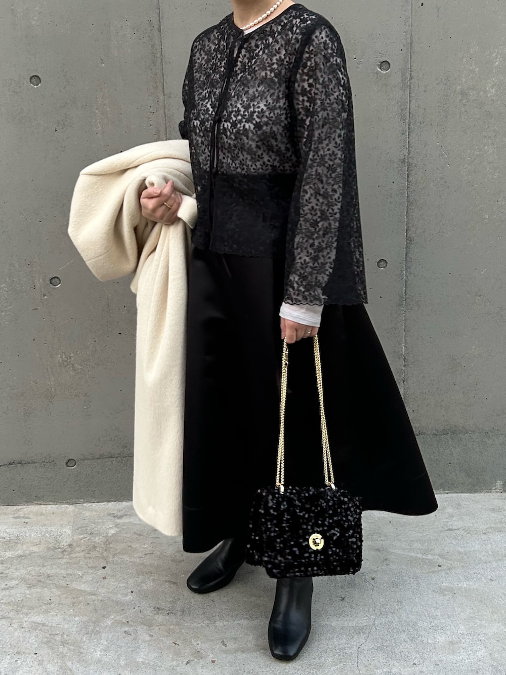 ブラック系のシャツ/ブラウス、ブラック系のショルダーバッグ、ベージュ系のTシャツ/カットソーを着用したレディースの冬コーディネートの4枚目の写真