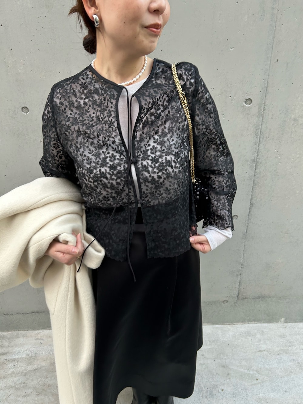 ブラック系のシャツ/ブラウス、ブラック系のショルダーバッグ、ベージュ系のTシャツ/カットソーを着用したレディースの冬コーディネートの5枚目の写真