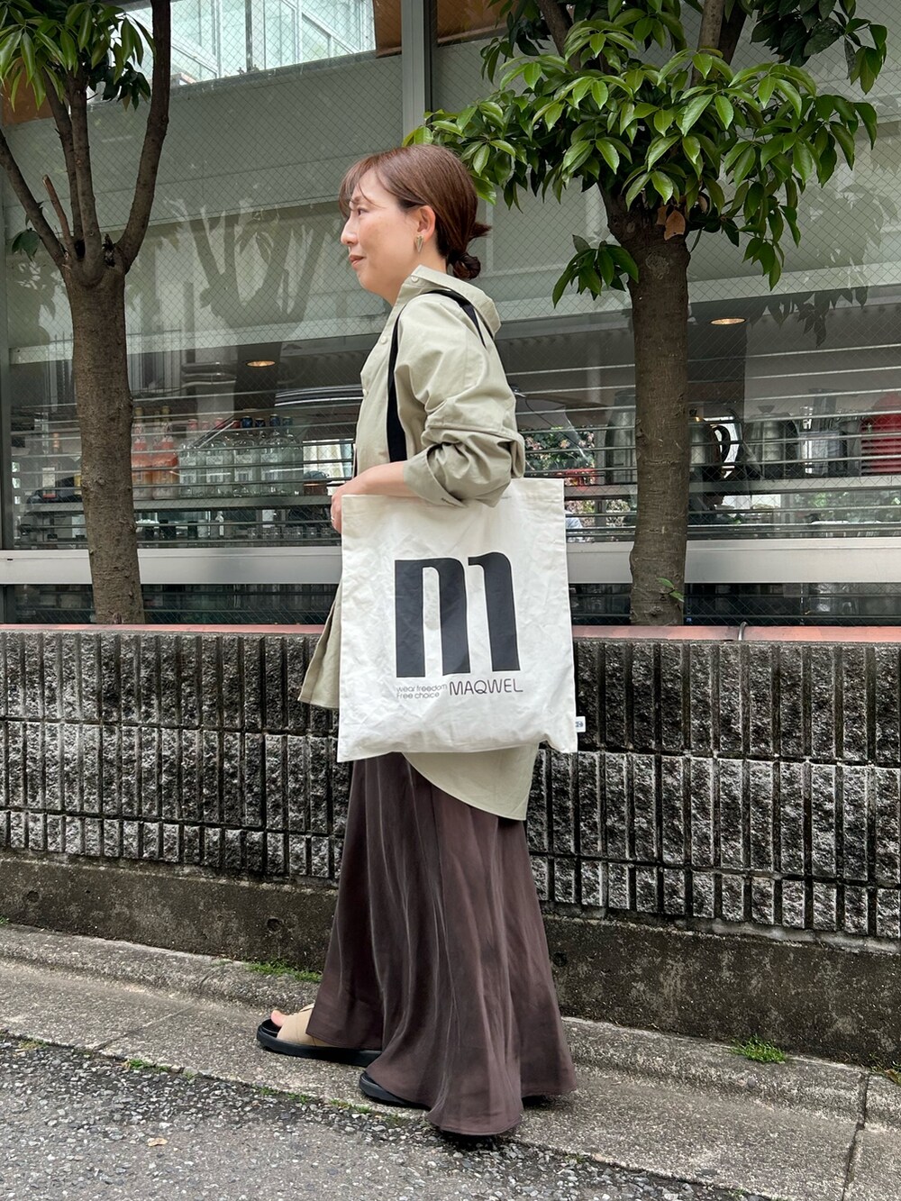 グリーン系のシャツ/ブラウス、ブラウン系のスカート、ベージュ系のサンダルを着用したレディースの夏コーディネートの3枚目の写真