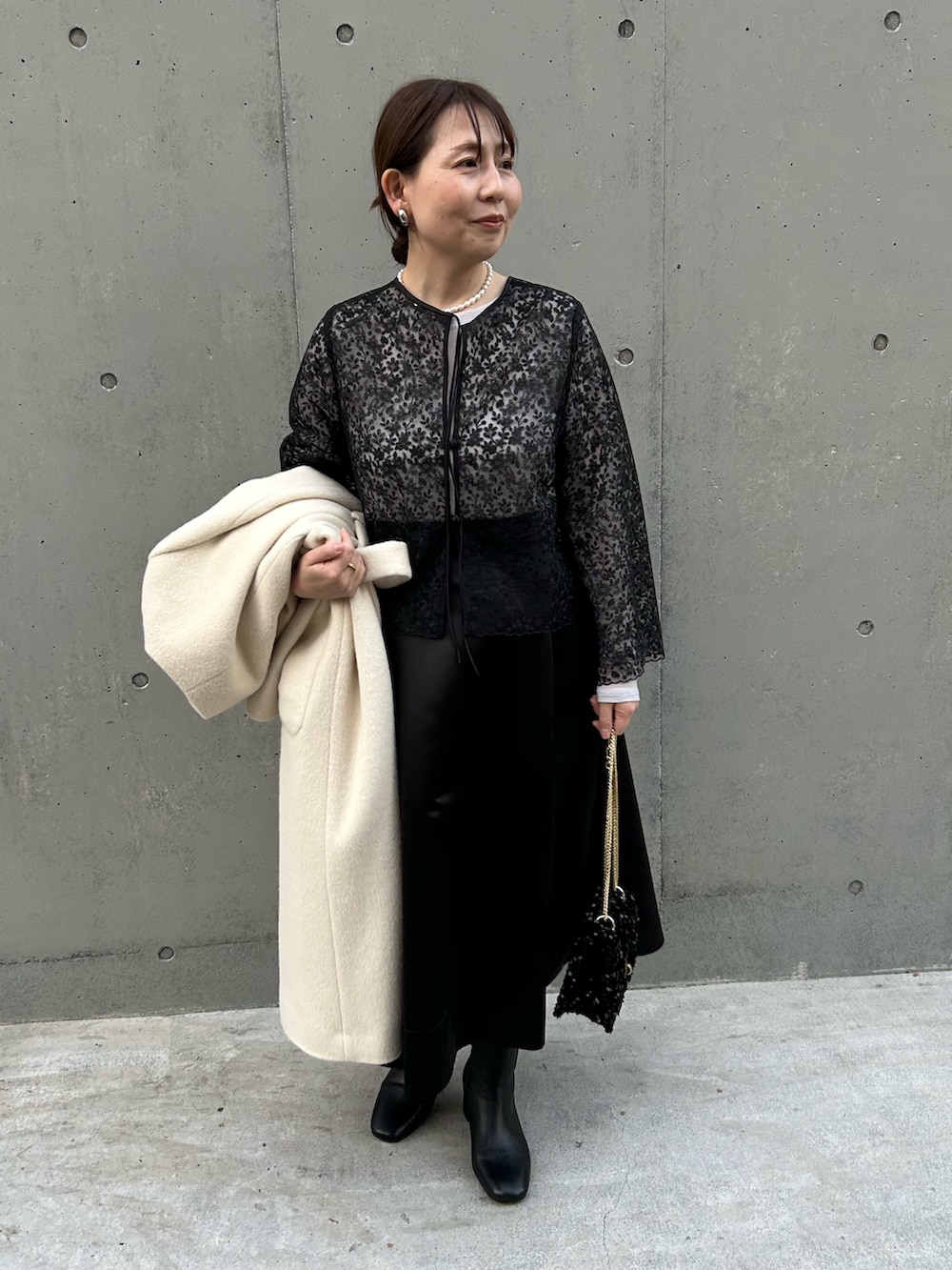 ブラック系のシャツ/ブラウス、ブラック系のショルダーバッグ、ベージュ系のTシャツ/カットソーを着用したレディースの冬コーディネートの2枚目の写真