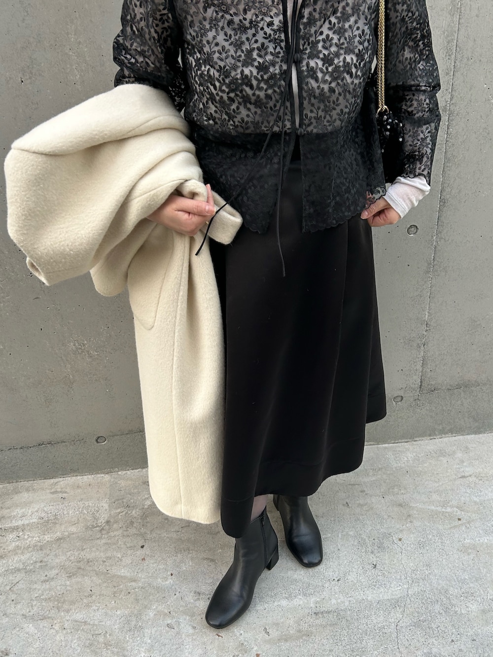 ブラック系のシャツ/ブラウス、ブラック系のショルダーバッグ、ベージュ系のTシャツ/カットソーを着用したレディースの冬コーディネートの6枚目の写真