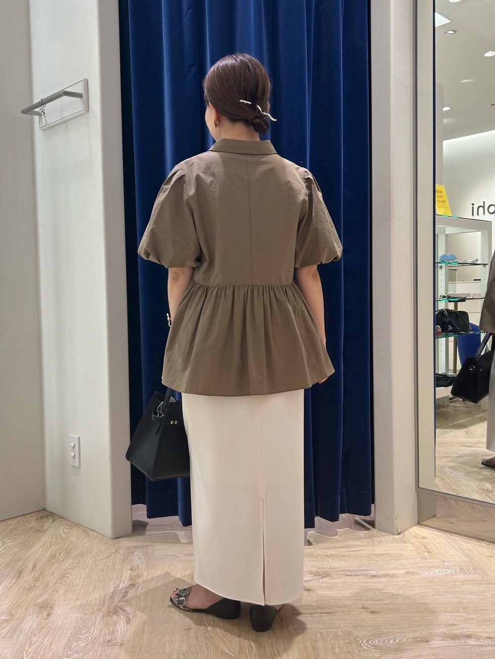 グリーン系のシャツ/ブラウス、ホワイト系のスカート、ブラック系のショルダーバッグを着用したレディースの夏コーディネートの3枚目の写真