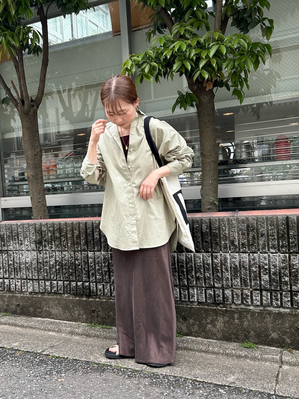 グリーン系のシャツ/ブラウス、ブラウン系のスカート、ベージュ系のサンダルを着用したレディースの夏コーディネートの2枚目の写真