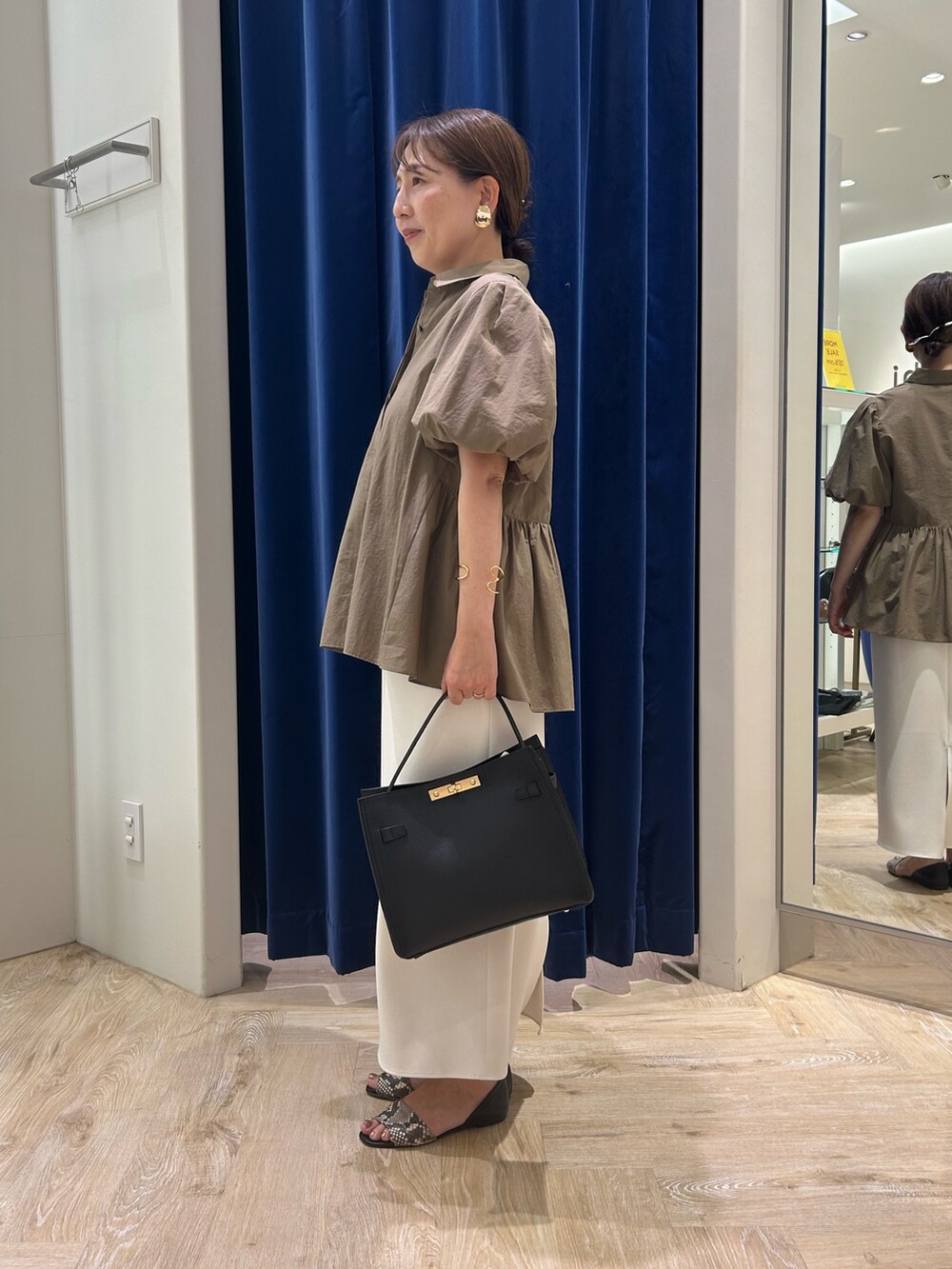 グリーン系のシャツ/ブラウス、ホワイト系のスカート、ブラック系のショルダーバッグを着用したレディースの夏コーディネートの2枚目の写真