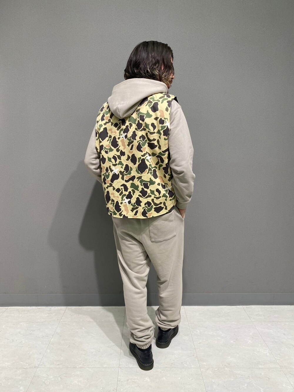 ブラック系のベスト、ベージュ系のスウェットパンツを着用したメンズの秋コーディネートの2枚目の写真