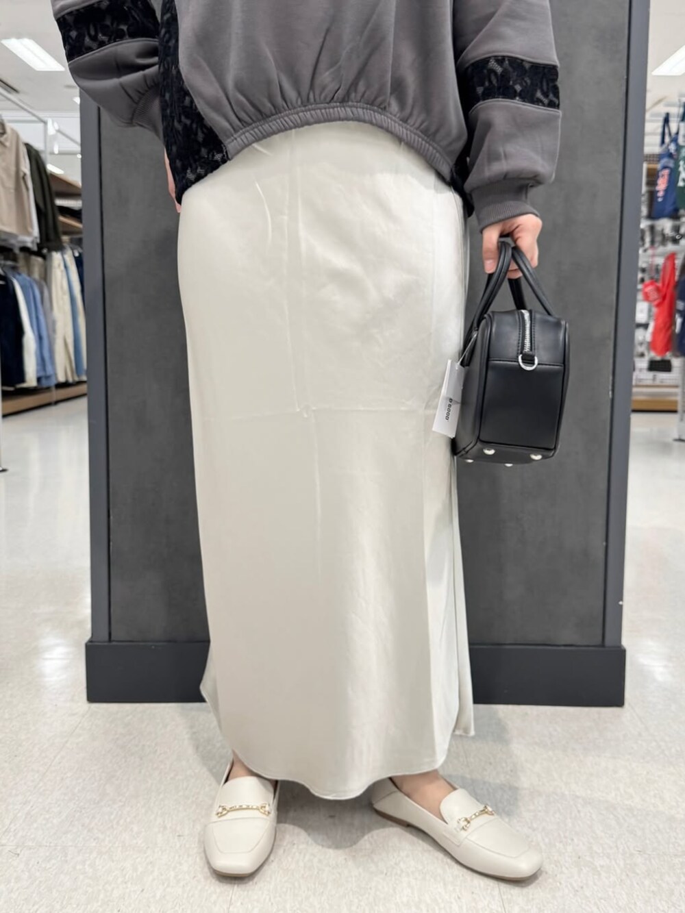 ベージュ系のスカート、グレー系のTシャツ/カットソーを着用したレディースの冬コーディネートの2枚目の写真