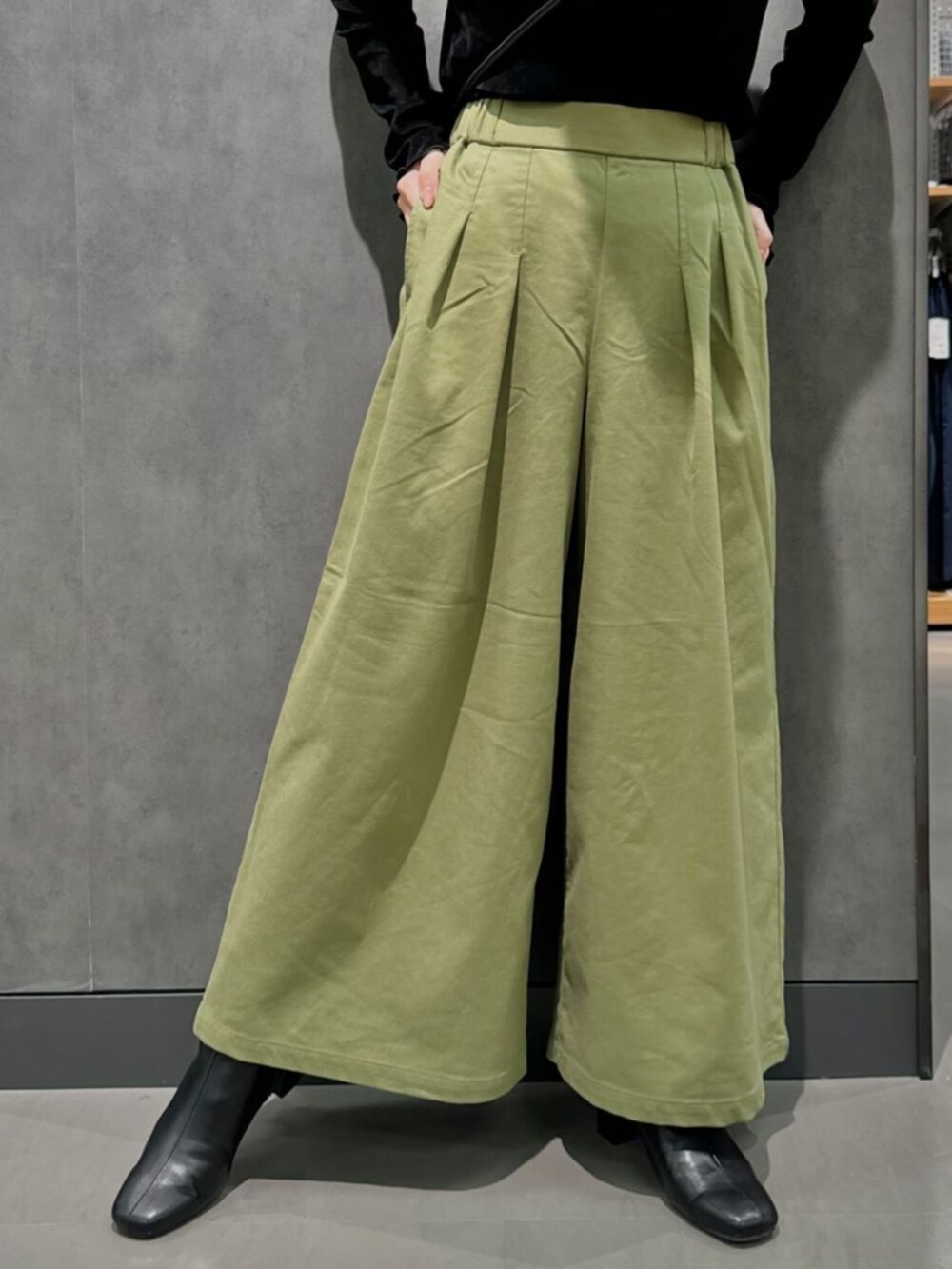 グリーン系のチノパンツを着用したレディースの秋コーディネートの2枚目の写真