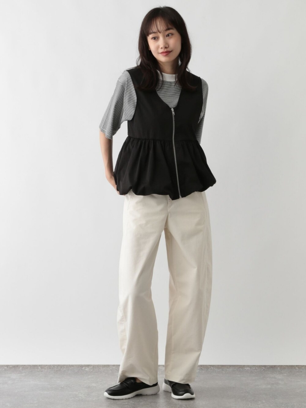 ブラック系のベストを着用したレディースの夏コーディネートの2枚目の写真